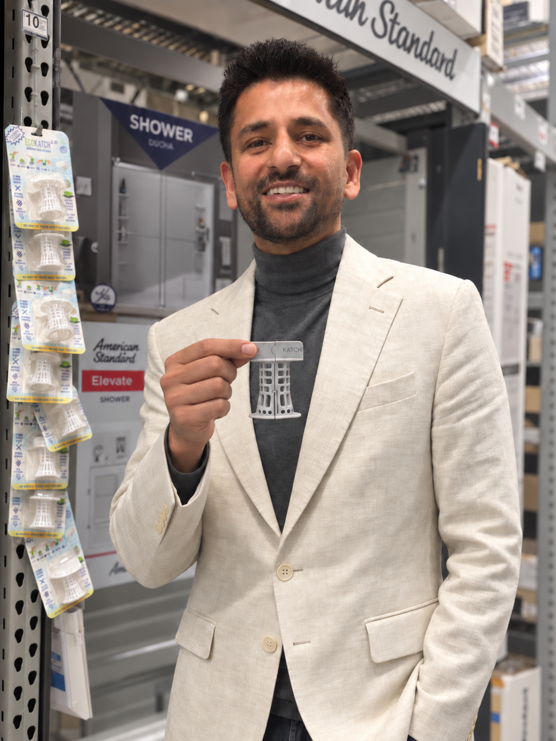 EcoKatch founder holding an EcoKatch bathtub drain hair catcher next to EcoKatch packages at Lowe's